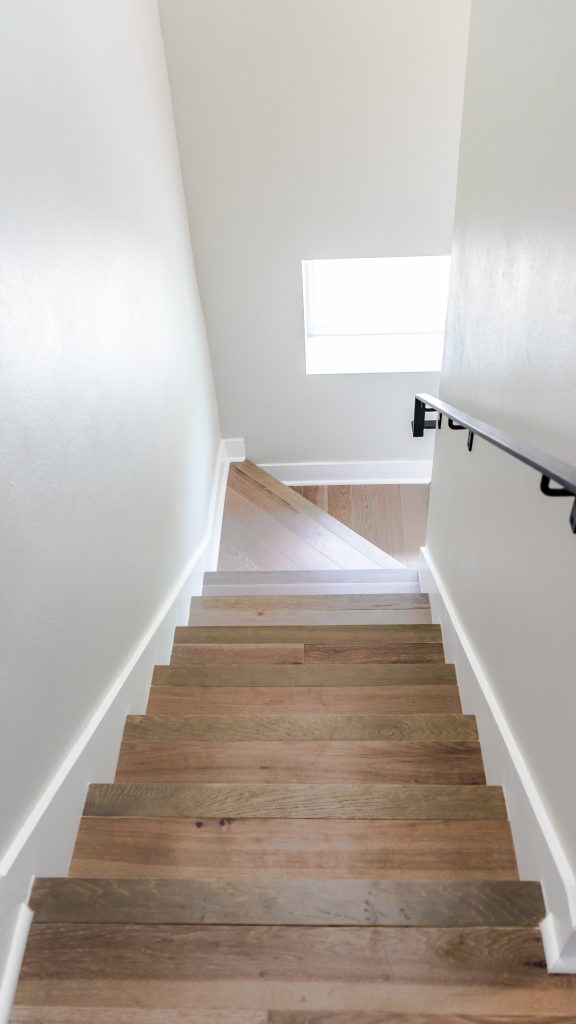 Voorbeeld van professionele traprenovatie met hernieuwde trapleuning en geschilderde treden voor DIY-project